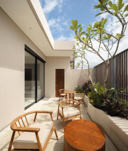 a patio with tables and chairs and a skylight at VOX Villas Canggu in Canggu