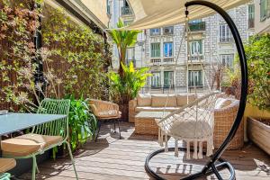 un patio con mesa y sillas en una terraza en Hôtel de France, un hôtel AMMI, en Niza