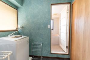 a bathroom with a washing machine and a mirror at Suite Room PayPayヤフオクドーム Darinホークス通り2F in Fukuoka +37 photos