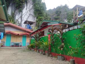 a group of houses in front of a mountain at Jammers Pension House in El Nido