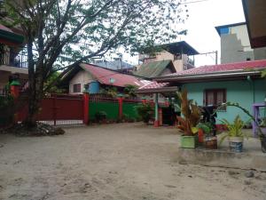 a house with a red fence and a yard at Jammer's Pension in El Nido +13 photos