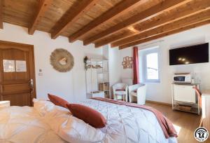 um quarto com uma cama e uma televisão na parede em La maison d'Hôtes Du Moulin em Lagardelle-sur-Lèze
