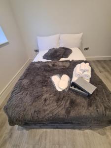 uma cama com chinelos e um livro em Luxury studio flat em Londres