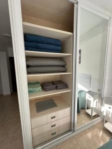 a closet with a mirror and some towels at Tamarindo 5 in Benalmádena