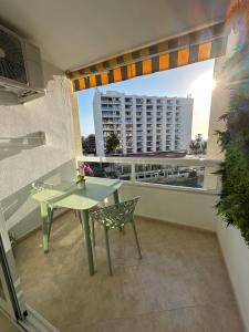 a table and a chair on a balcony with a building at Tamarindo 5 in Benalmádena
