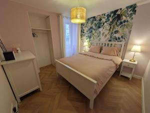 a bedroom with a large bed with a floral wallpaper at Appartement avec jardin et accès mer in Grandcamp-Maisy