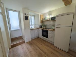 a kitchen with a white refrigerator and a window at Appartement avec jardin et accès mer in Grandcamp-Maisy +18 photos