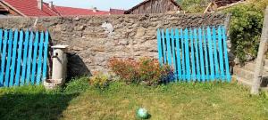 a blue fence next to a stone wall at Casa Turcoaz in Sviniţa