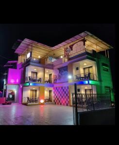 a large building with purple and green lights on it at Cornerpoint bungalows in Alibaug