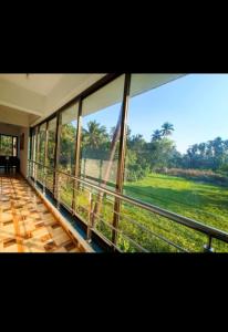 a room with a large window looking out at a field at Cornerpoint bungalows in Alibaug