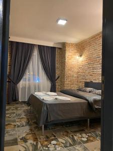 a bedroom with a bed and a brick wall at Tüyap Fair Elit Home in Istanbul
