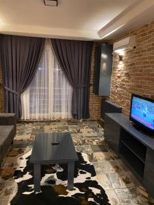 Tüyap Fair Elit Home في إسطنبول: غرفة معيشة بها أريكة وطاولة وتلفزيون