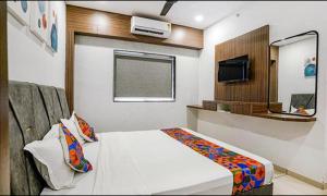 a room with a bed and a television in it at FabHotel Fortune in Surat