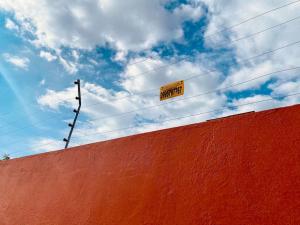 un letrero de calle amarillo en la parte superior de una pared en Villa Mirlo – Escondite de Lujo en Quito, en Quito