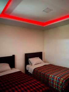 Habitación con 2 camas y techo rojo. en Villa Mirlo – Escondite de Lujo en Quito en Quito