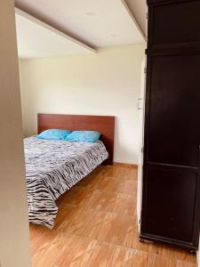 Un dormitorio con una cama con almohadas azules. en Villa Mirlo – Escondite de Lujo en Quito en Quito