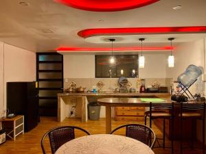 cocina con mesa y sillas y techo rojo en Villa Mirlo – Escondite de Lujo en Quito en Quito