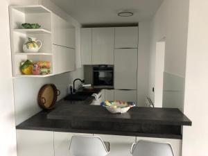 uma cozinha com armários brancos e uma taça de fruta no balcão em Apartment R24/7, 4050 Traun em Linz