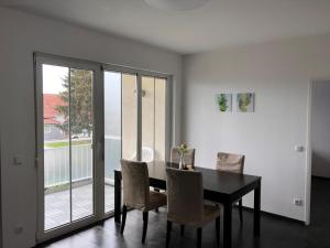 uma sala de jantar com uma mesa preta e cadeiras em Apartment R24/7, 4050 Traun em Linz