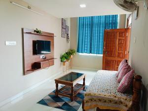 ein Wohnzimmer mit einem Sofa und einem Couchtisch in der Unterkunft Cozy 2BHK flat @ Vijaynagar 2nd stage Mysore in Mysore