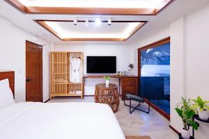 a bedroom with a bed and a flat screen tv at Morgan Villas in El Nido