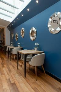a dining room with blue walls and tables and chairs at La Petite Fugue in Beaune