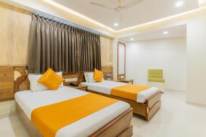 Cette chambre comprend 2 lits et une fenêtre. dans l'établissement Hotel Prime, à Ahmedabad