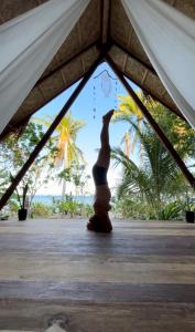 una mujer parada en una tienda con sus brazos en el aire en Harmony Healing Project - Connect With Your Divinity en El Nido