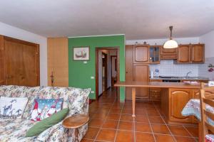 a living room with a couch and a kitchen at Maison Miravalle in Colle Santa Lucia