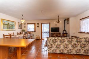 a living room with a table and a couch at Maison Miravalle in Colle Santa Lucia