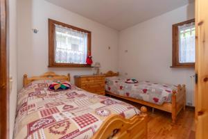a bedroom with two beds and two windows at Maison Miravalle in Colle Santa Lucia