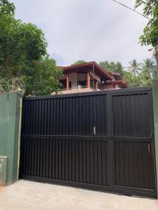 um portão preto em frente a uma casa em Serendip Villa Holiday Home Talalla Sri Lanka em Talalla South