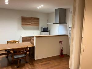 a small kitchen with a wooden table and a dining room at Leaf Village in Tokorozawa