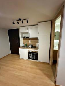 cocina con armarios blancos y suelo de madera en Coastal Escape, en Kavala