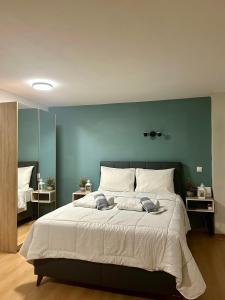 1 dormitorio con 1 cama grande y pared azul en Coastal Escape, en Kavala