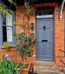 una puerta azul en el lateral de una casa de ladrillo en Inviting 2-Bed Character House Stamford, en Lincolnshire