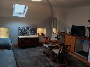 a bedroom with a bed and a desk with a table at Oak Tree Lane Country B and B in Bridgetown