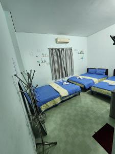 a room with three beds with blue sheets in it at Motel Thành Đạt in Vung Tau