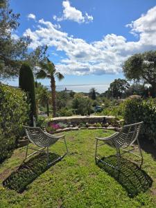 two chairs sitting in the grass in a garden at Perle d'or vue mer in Saint-Raphaël