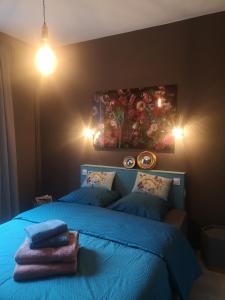 Un dormitorio con una cama azul con sábanas y almohadas azules en Chez Mikki, en Cassaniouze