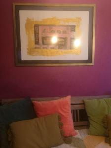 una pintura sobre un sofá con almohadas coloridas en Chez Mikki, en Cassaniouze