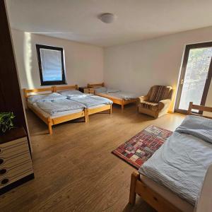 a room with two beds and a chair at Adventure Farm in Štore