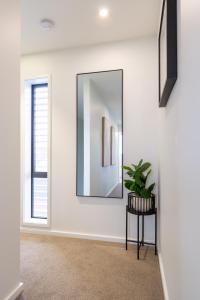 Relaxing City Hideaway - 2 Bed in Christchurch CBD في كرايستشيرش: ممر به مرآة وزرع على طاولة