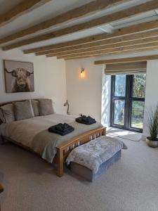 a bedroom with a large bed and a large window at The Barn in Shirland