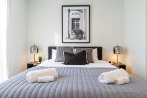 Relaxing City Hideaway - 2 Bed in Christchurch CBD في كرايستشيرش: غرفة نوم بها سرير كبير عليه منشفتين