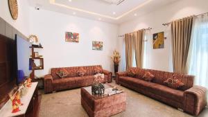 - un salon avec deux canapés bruns et une table dans l'établissement Blessings Hotel, à Amritsar