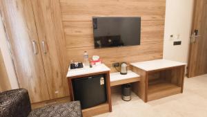 a room with a tv and a sink and a desk at Blessings Hotel in Amritsar