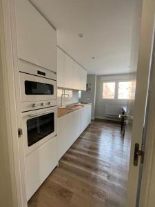 uma cozinha com electrodomésticos brancos e piso em madeira em Rooms Madrid Río em Madri