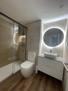 a bathroom with a toilet and a sink and a mirror at Rooms Madrid Río in Madrid
