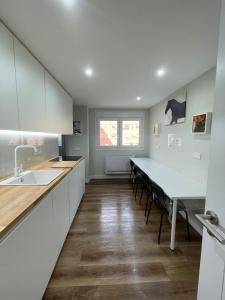 a kitchen with white cabinets and a dining table at Rooms Madrid Río in Madrid